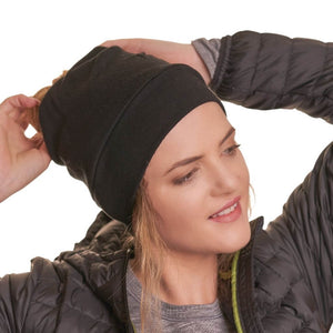 Women wearing ZQ merino wool ponytail friendly beanie while adjusting ponytail
