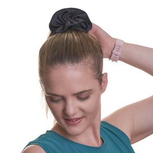 women wearing black exercise scrunchie looking to the ground