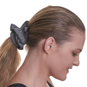 Women wearing a grey scrunchie looking to the ground