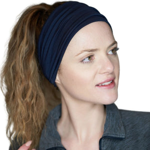 Women looking to the left wearing a wide blue bamboo exercise headband