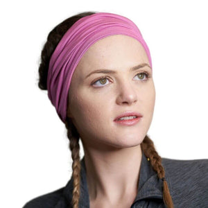 Women wearing light pink bamboo yoga headband looking to the left
