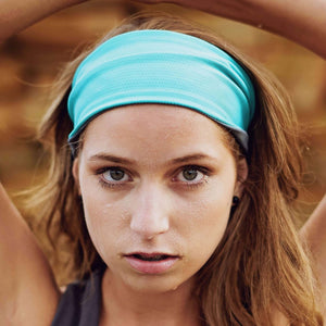 Women wearing a aqua/gray reversible running headband