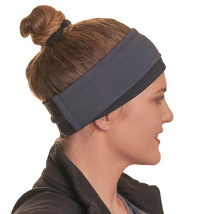 Side view of women smiling while wearing grey and black reversible pony tail friendly winter headband