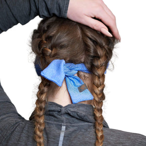 Back view of women wearing blue adjustable tie behind sports headband