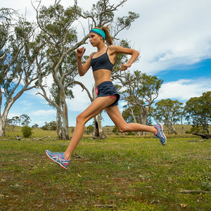 Women running while wearing an aqua/gray reversible exercise headband