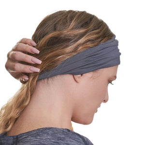 Side view of women wearing grey bamboo yoga sweatband holding hair back.