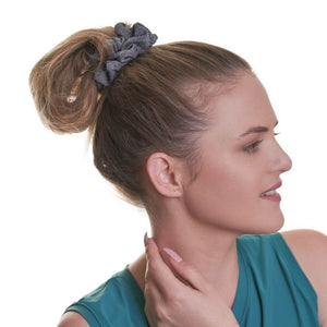 Women looking sideways wearing grey running scrunchie with hand on neck wearing aqua sports tank