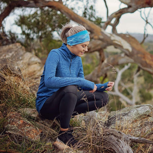 women in the bush hiking wearing blue-aqua reversible winter sports headband