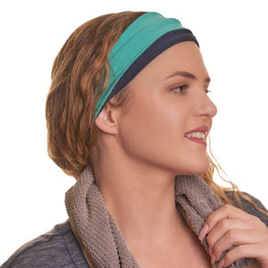 Women wearing reversible sports headband with grey towel around her neck looking left
