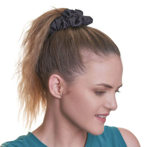 Women wearing black hiking scrunchie made from fabric offcuts, looking left wearing a aqua tank top.