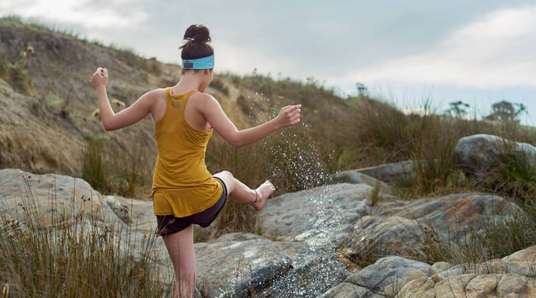 women kicking water outside wearing a sports heabband