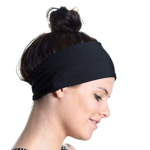 Women wearing a black reversible sports headband gazing to the ground
