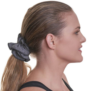 Side view of women wearing grey scrunchie holding up her ponytail