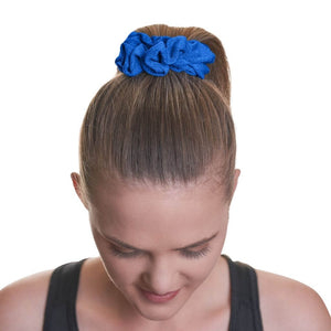 Women wearing dark blue exercise scrunchie in high ponytail gazing to the ground