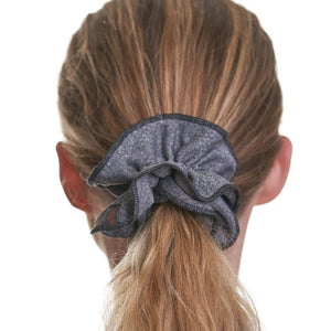 Close up of grey scrunchie with black trimming being used to hold up a ponytail