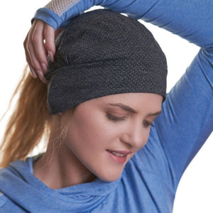 women looking towards the ground with arm over head wearing merino wool beanie