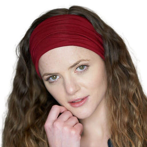 Women wearing red sports bamboo headwrap with hand under chin