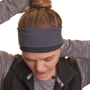 Close up of black and graphite reversible winter headband with women gazing to the ground.