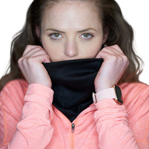 Women wearing black merino wool neck warmer holding up as mask