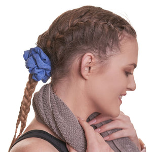 side view of women wearing blue workout scrunchie with towel around her neck looking left