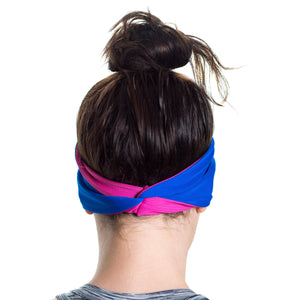 Back view of Women wearing a pink/blue reversible sports headband highlighting twist