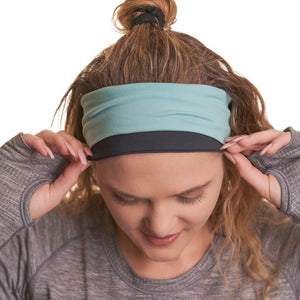 Women wearing ponytail friendly reversible winter ear warmers / headband while gazing at the ground