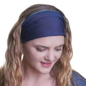 Women gazing onto the ground wearing her blue and aqua reversible headband wide over her hair
