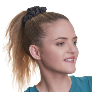 women wearing black workout scrunchie looking to the left